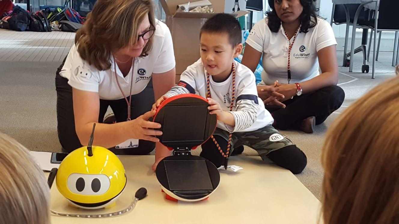 Begeleider laat een leerling een educatieve robot ontdekken