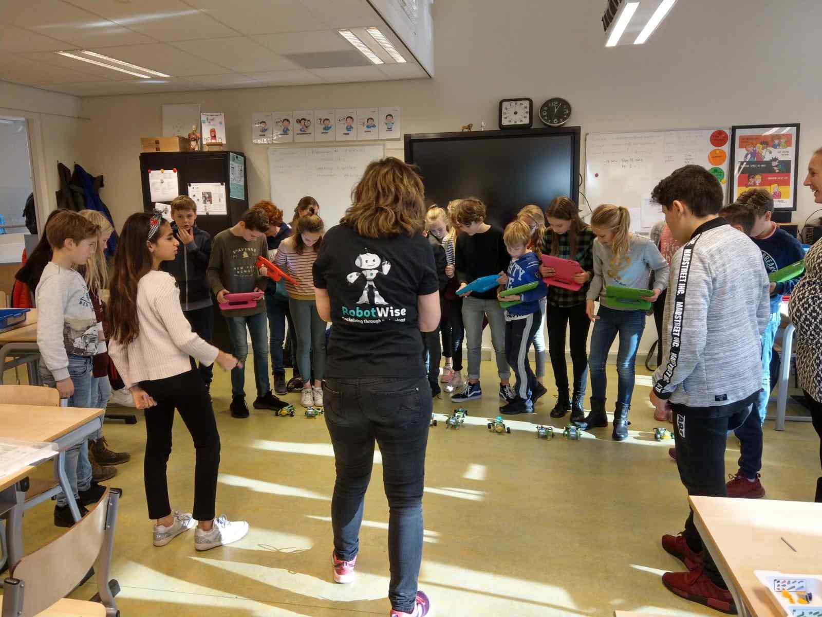 Leerlingen volgen met tablets een robotparcours in het klaslokaal