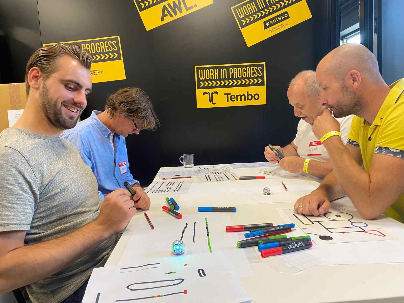 Medewerkers oefenen tijdens de co-teacher training met kleine robots